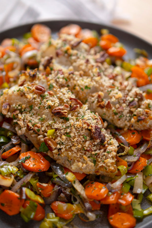 Honey Mustard-Pecan Crusted Cod laying over a bed of vegetables
